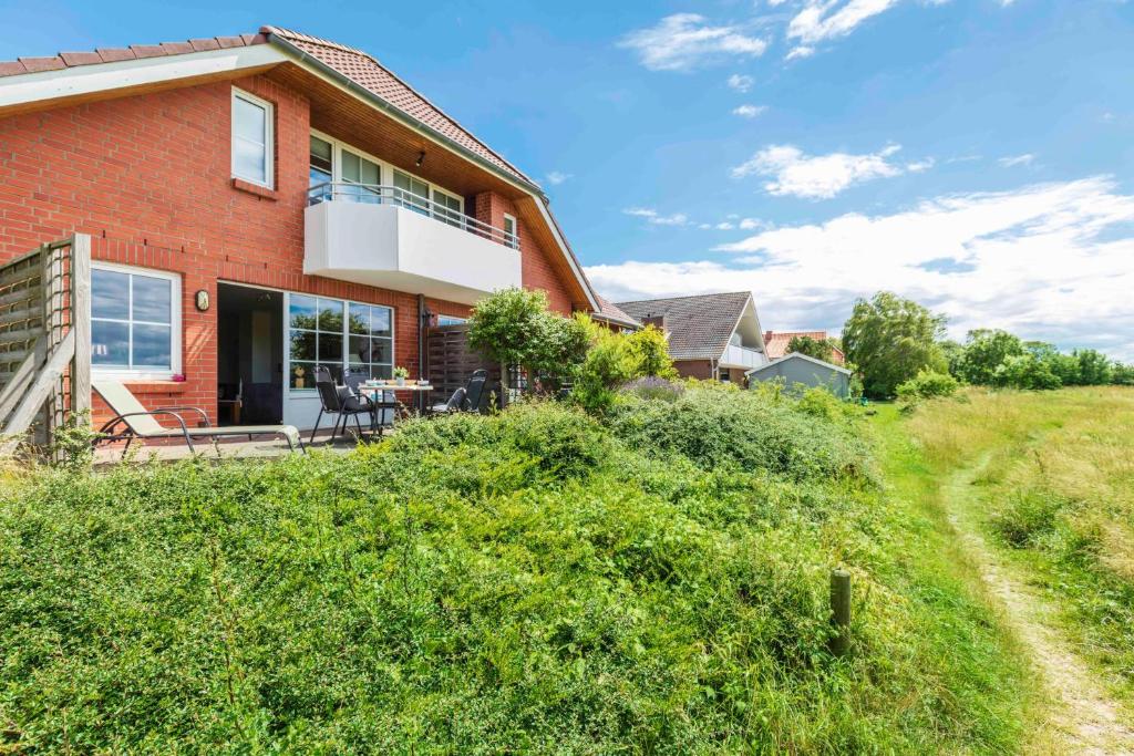 a red brick house on a hill with a yard at NTBM36001-Binnenseeblick in Neue Tiefe Fehmarn