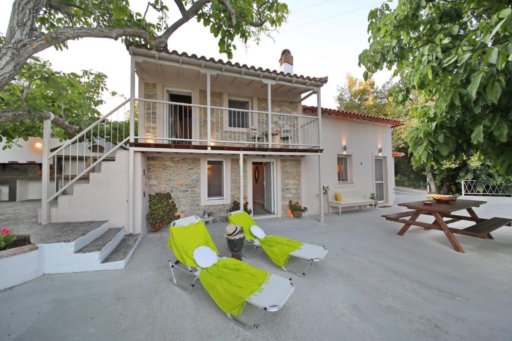 a house with a patio with chairs and a table at Pyrgos Country House in Skopelos Town