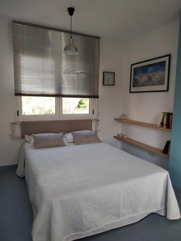 a bedroom with a white bed and a window at Apartamento Waiora in Aguaviva