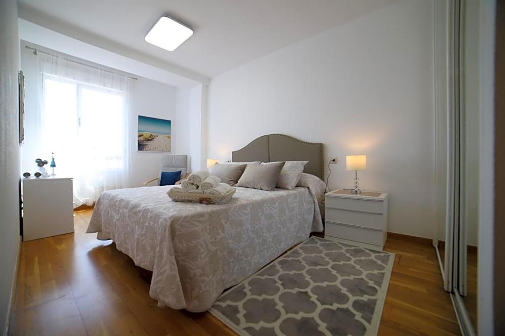 a bedroom with a large bed and a window at LA LUZ DEL ARBEYAL L&G in Gijón