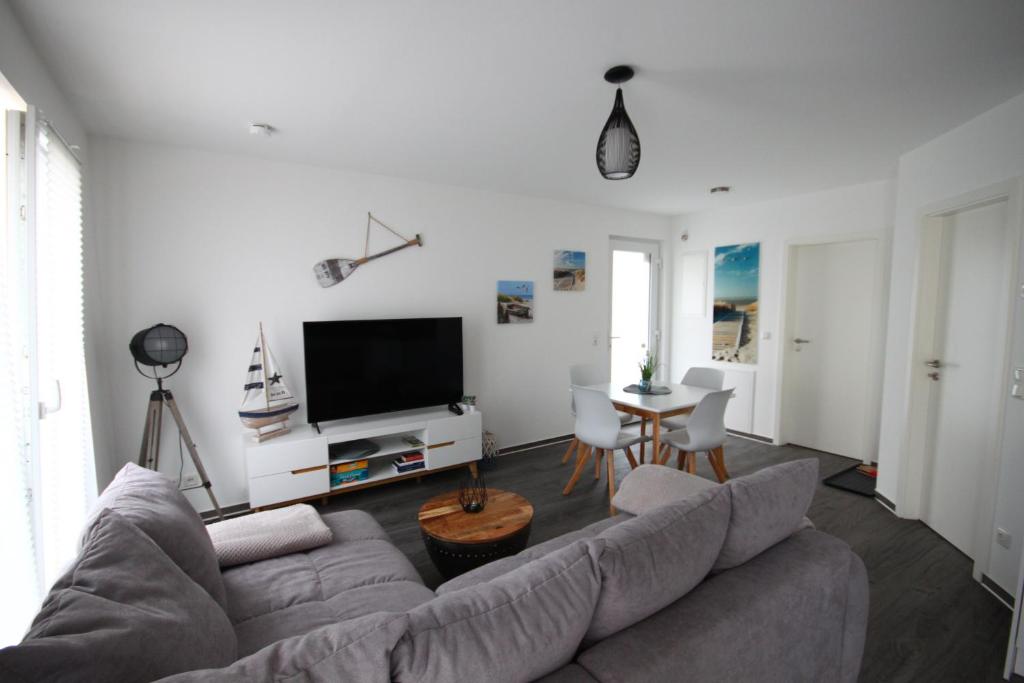 Küstenliebe 8 في غرال موريتز: غرفة معيشة بها أريكة وطاولة
