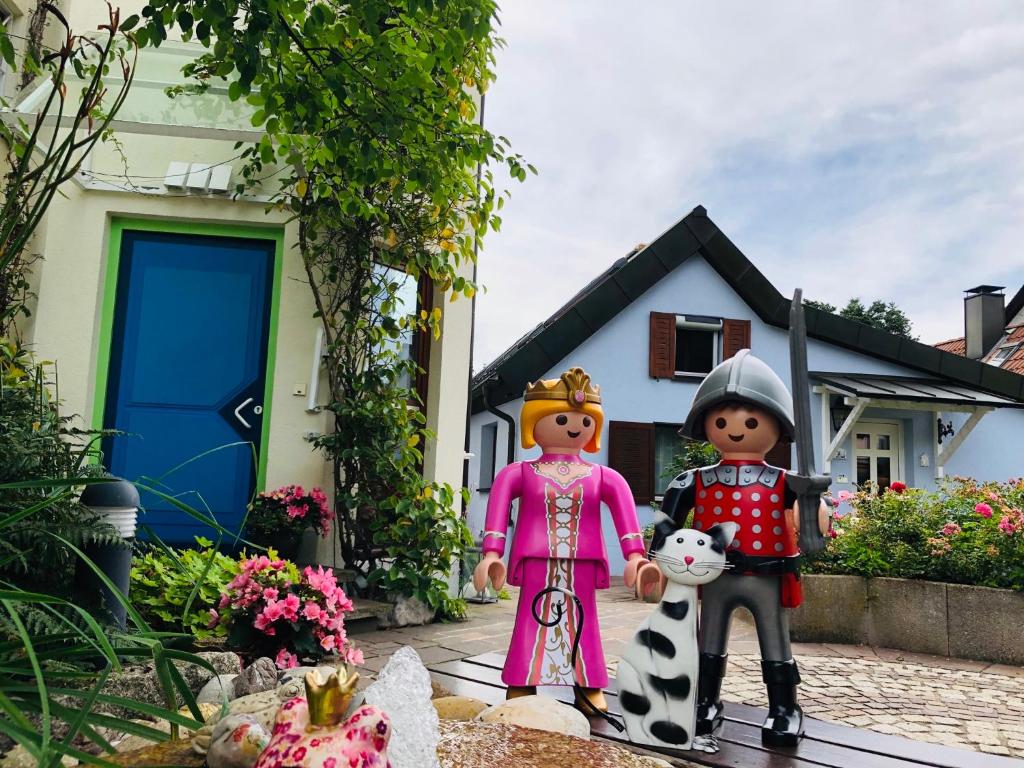 un grupo de figuritas de juguete parados frente a una casa en CASA LOFT & LaMansarda, en Zirndorf