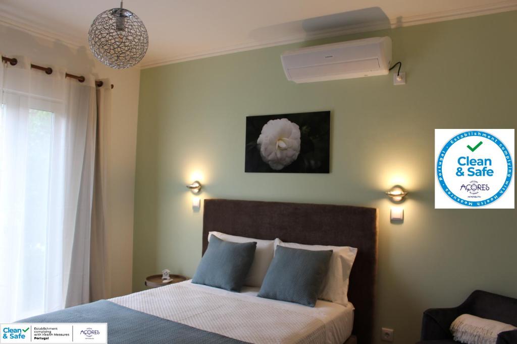 1 dormitorio con 1 cama con almohadas azules en Cantinho da Luz en Ponta Delgada