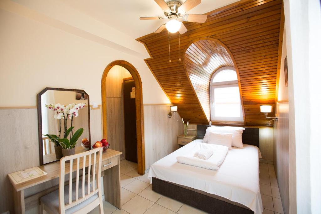 1 dormitorio con cama blanca y espejo en Passzio Panzio, en Budapest