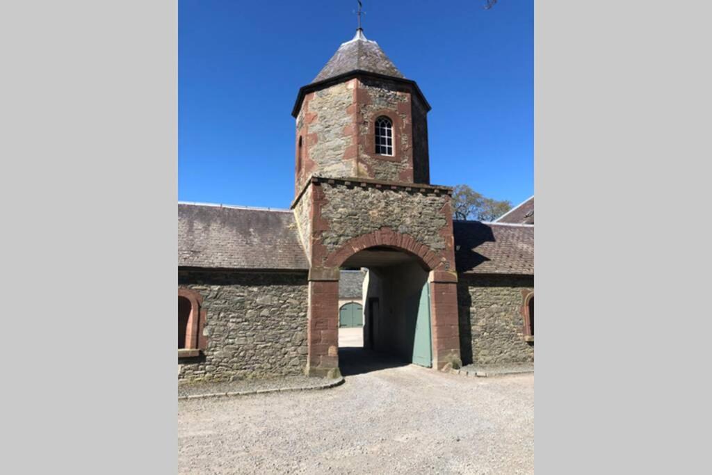 uma velha igreja com uma torre e uma porta em Barns Library em Peebles