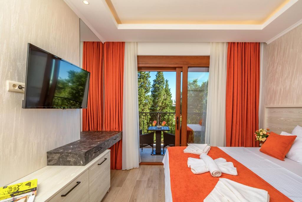 a hotel room with a television and a bed at Luxury Apartments Queen in Petrovac na Moru