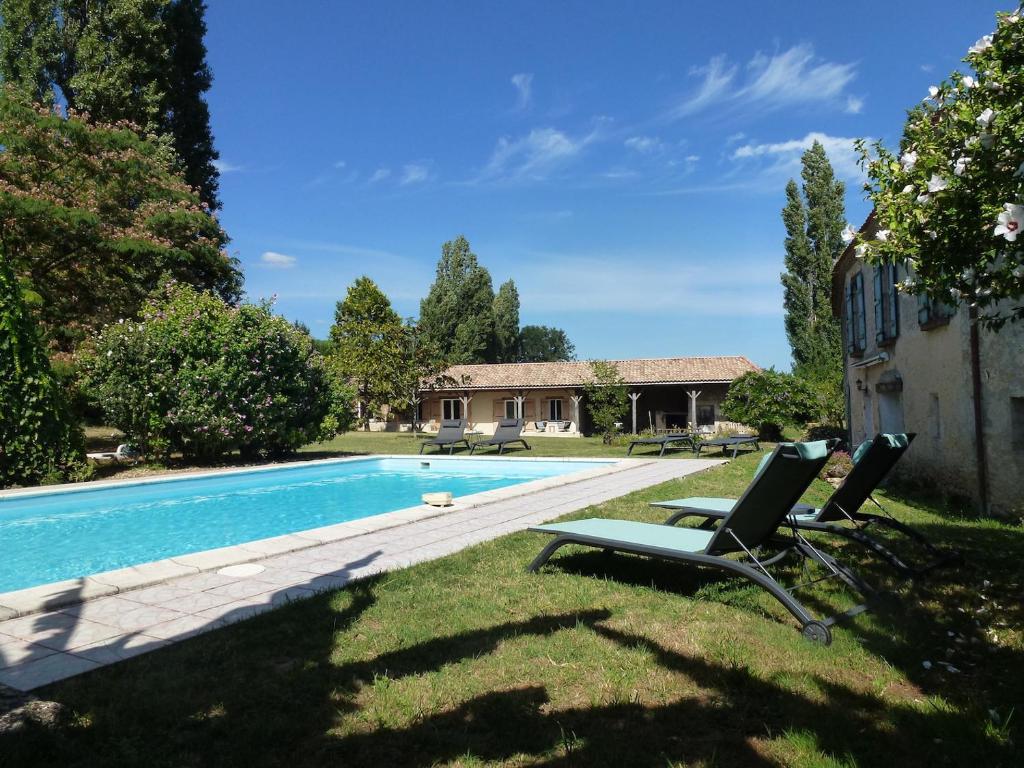 une cour avec une piscine et deux chaises longues dans l'établissement Au petit grain, à Coutures