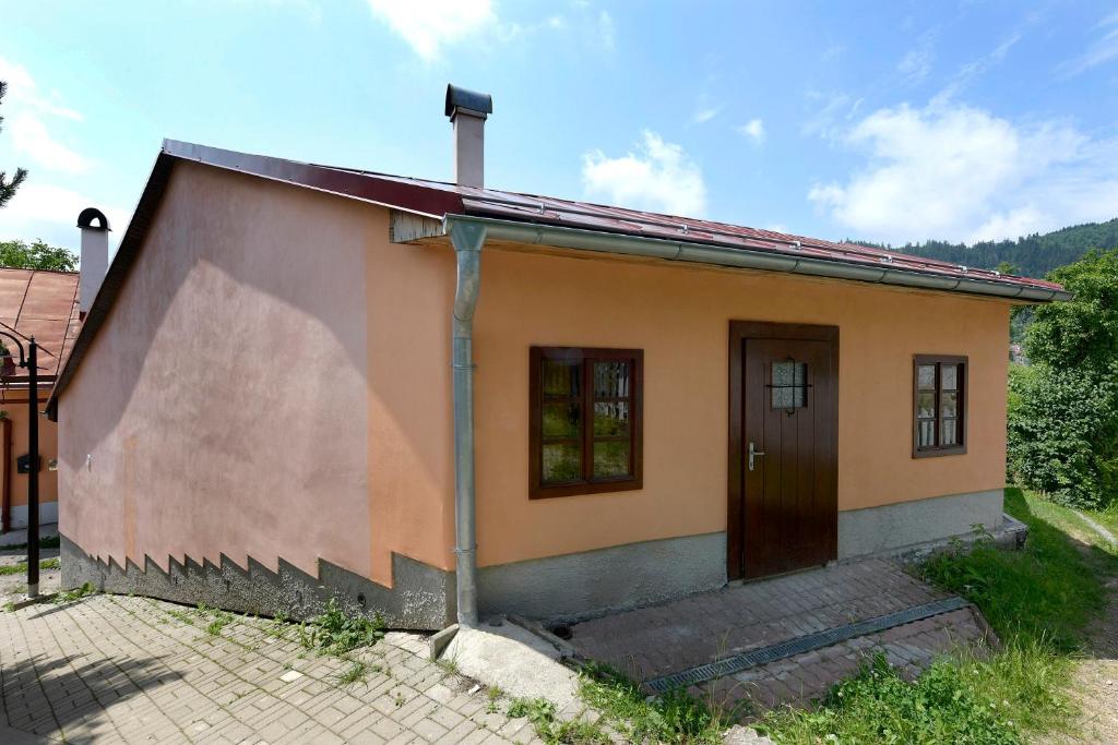 a small house with a brown door in a yard at ubytovanie-stiavnica in Banská Štiavnica