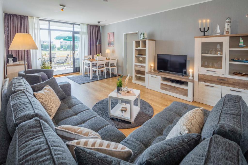 uma sala de estar com um sofá e uma televisão em Strandkorb em Fehmarn