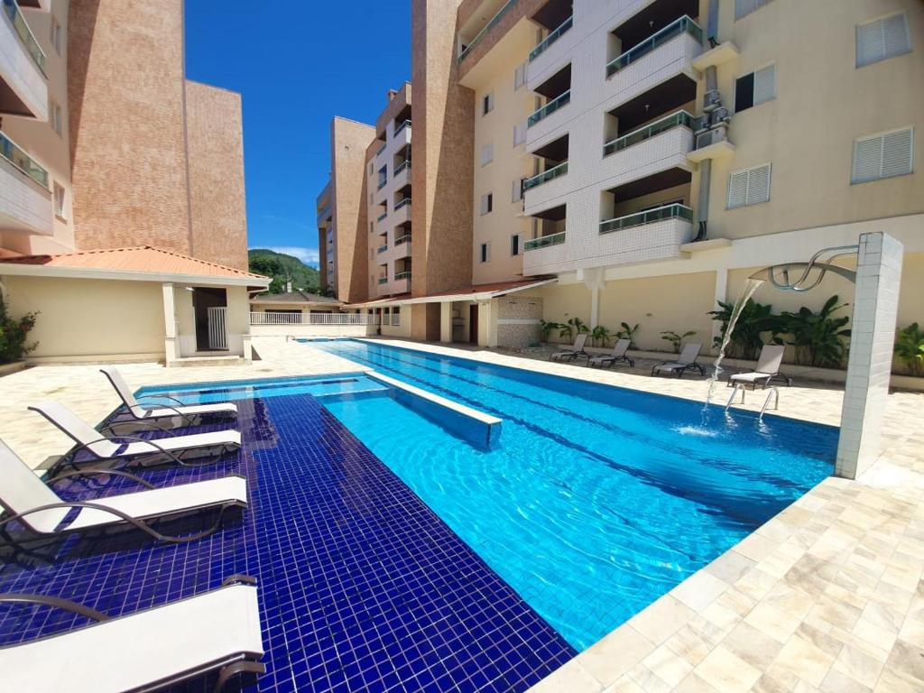 una piscina en medio de un edificio en Apartamento Praia das Toninhas, 3 min do Mar, en Ubatuba