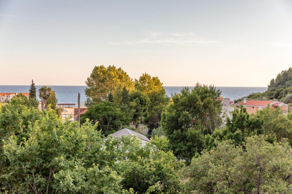 a view of the ocean from behind trees at Luxury Apartments Queen in Petrovac na Moru