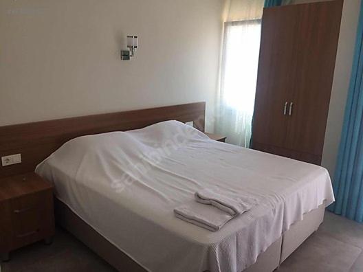 a bedroom with a bed with white sheets and a window at Mediterranean apart hotel in Fethiye