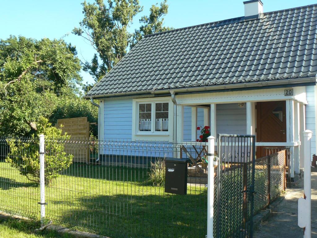 una pequeña casa con una valla en el patio en Blue house, en Suchedniów