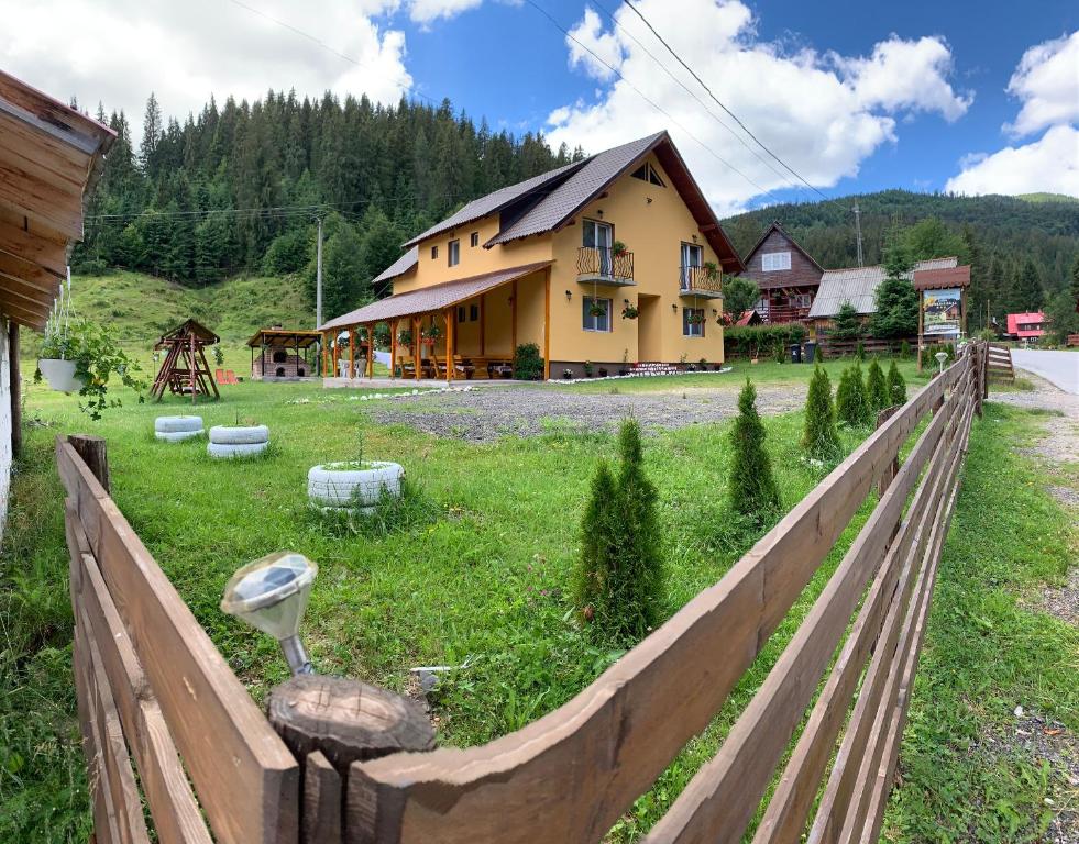 une clôture en bois avec une maison en arrière-plan dans l'établissement Casa Natalia Raisa Arieșeni, à Arieşeni