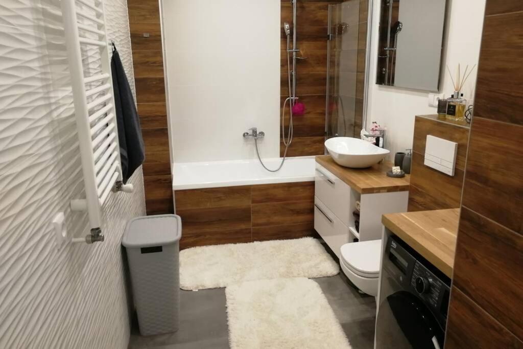 a bathroom with a toilet and a sink and a tub at NOVA Apartment in Sanok