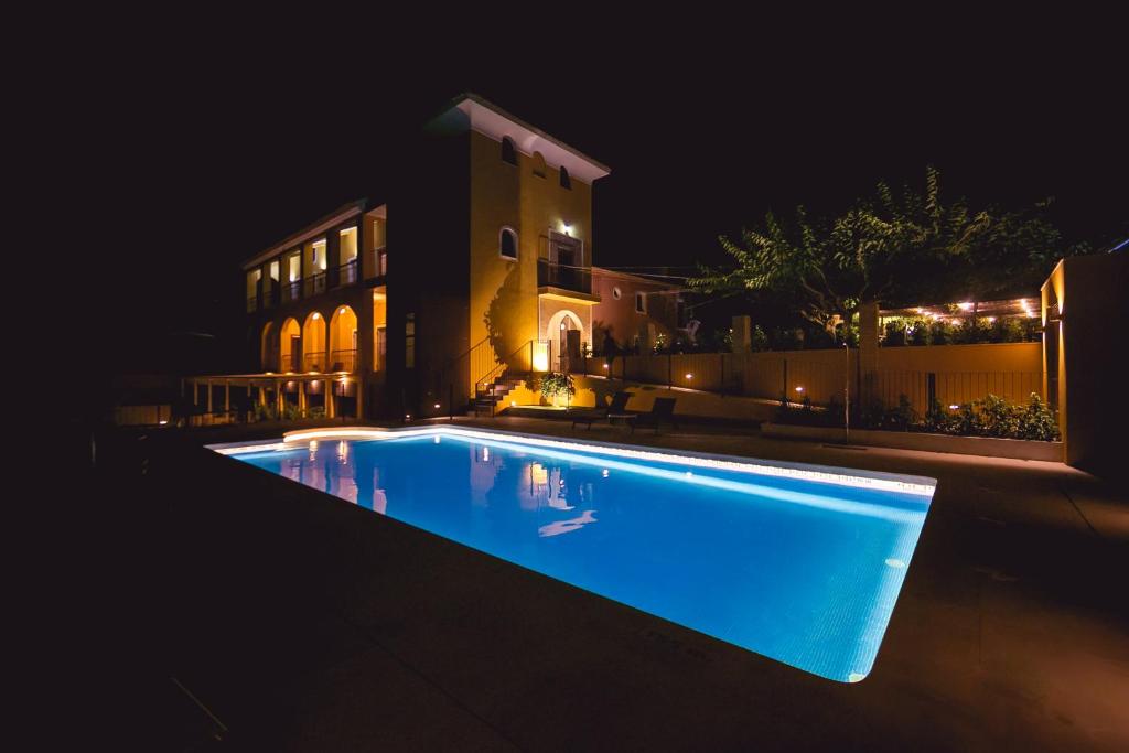 a swimming pool in front of a house at night at Hotel Rural El Molino de Felipe in Mula