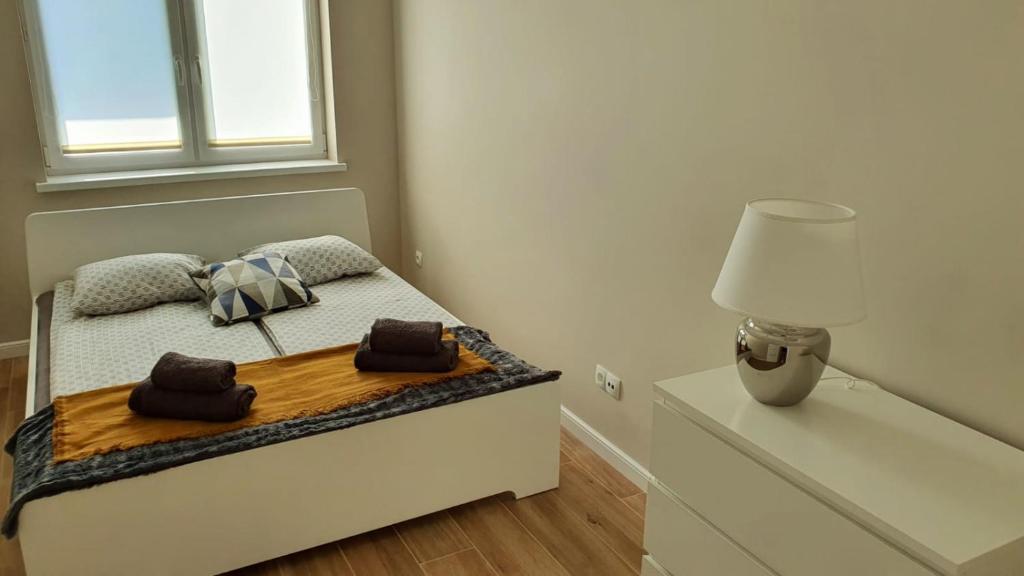 a small bedroom with a bed with a lamp on it at APARTAMENT WILKASY II (k. Giżycka ) in Wilkasy