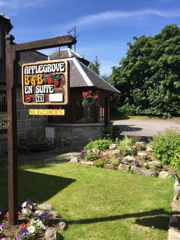 a sign in front of a house with a garden at Applegrove B&B in Boat of Garten