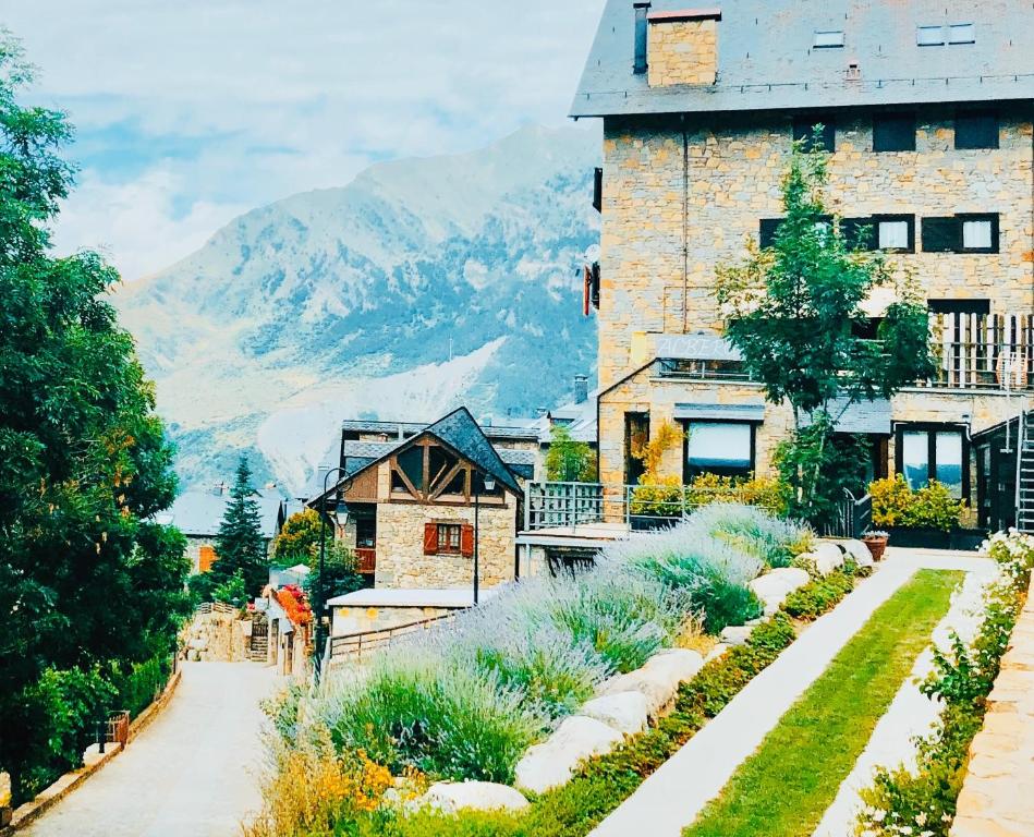 a house with a garden and mountains in the background at Alberg Taull in Taüll