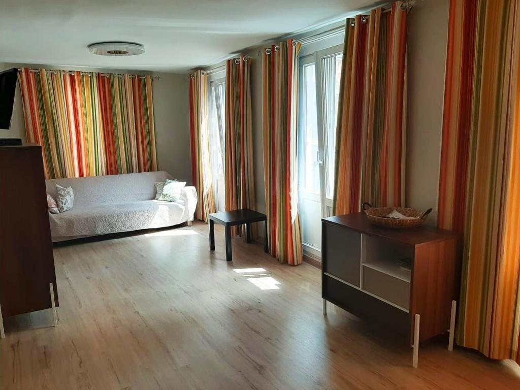 ein Wohnzimmer mit einem Bett und einem Tisch in der Unterkunft Piso céntrico en Santander in Santander
