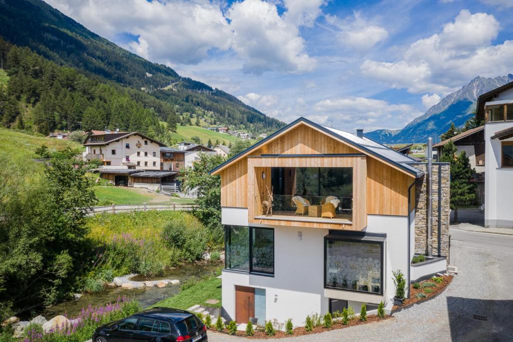 a house with a large window on the side of it at Chalet Ortles Apt ll in San Valentino alla Muta