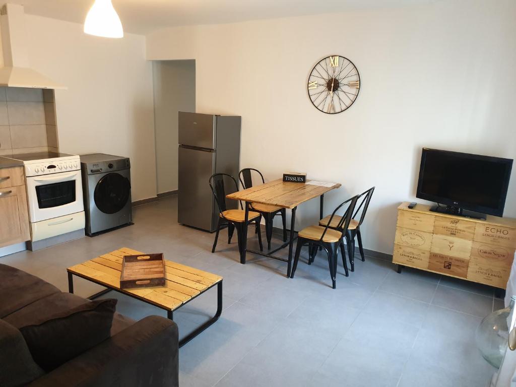 ein Wohnzimmer mit einem Tisch und Stühlen sowie eine Küche in der Unterkunft Atelier n°4 in Fontaine-de-Vaucluse