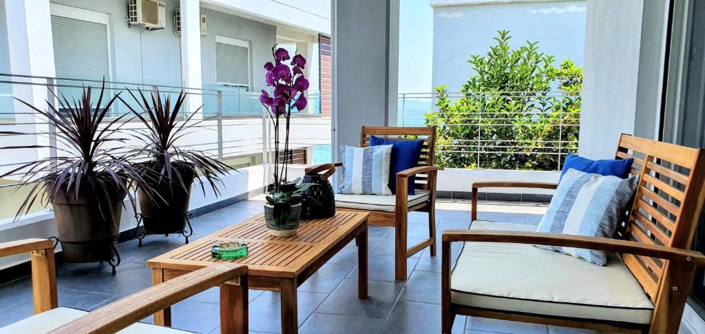 a balcony with two chairs and a table and some plants at Amare Luxury Living in Volos