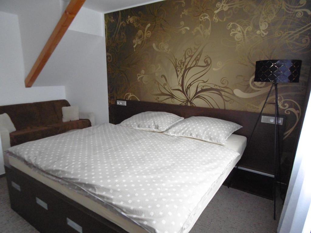 a bedroom with a large bed with a wall at Apartmány Rosijo in Lednice