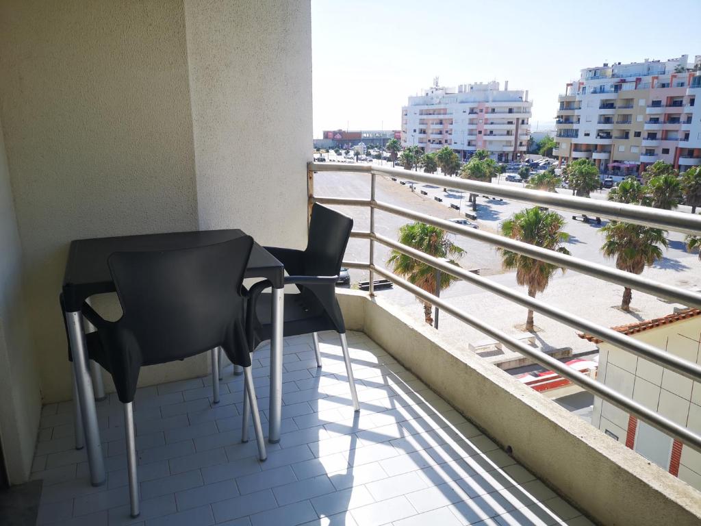 uma varanda com mesa e cadeiras e vista para a praia em Caparica Apartment 3C em Costa da Caparica