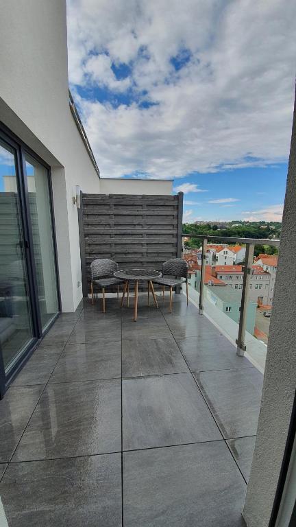 balkon ze stołem i krzesłami na budynku w obiekcie Magic Apartment centre Pilsen w Pilznie