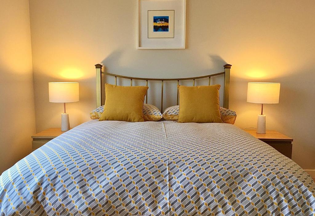 a bedroom with a large bed with two lamps at Park House in Port of Ness