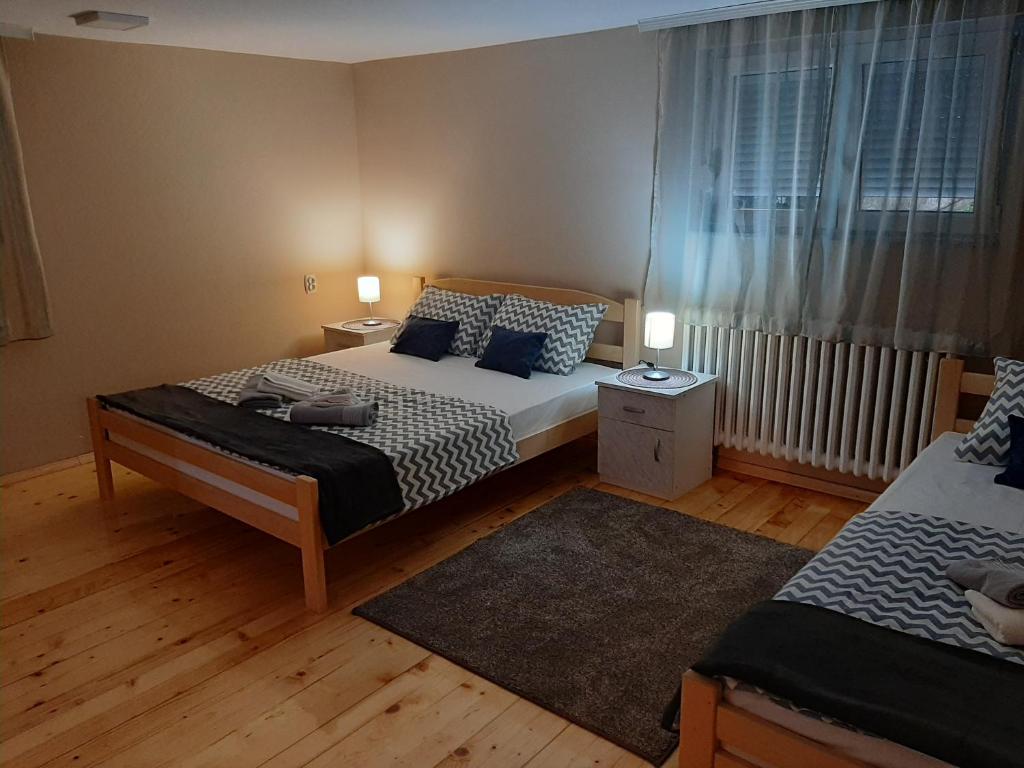 a small bedroom with two beds and a window at Apartman Talija in Arandjelovac