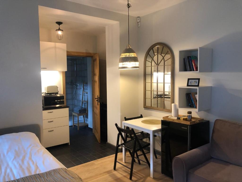 um quarto com uma cama, uma mesa e uma cozinha em Sisters Beach Apartments em Liepāja