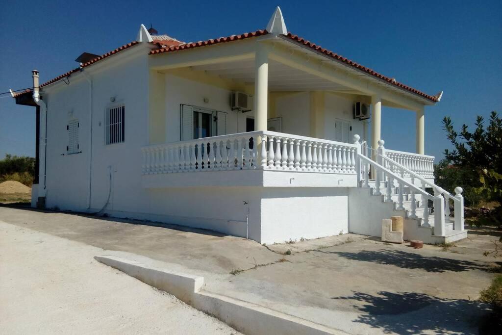 ein weißes Haus mit einer weißen Veranda und einer Treppe in der Unterkunft Marinis House in Koroni
