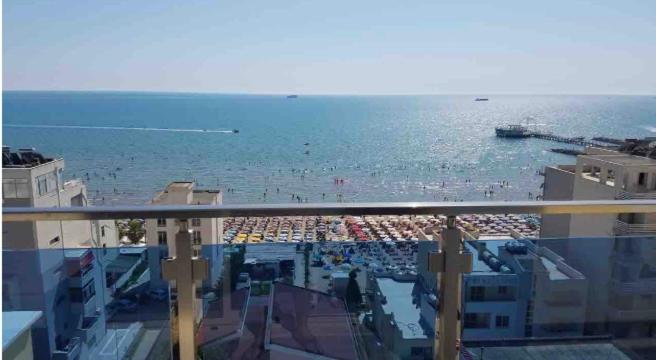 uitzicht op een strand vanaf het balkon van een gebouw bij Adriatic Seaview Apartment in Durrës