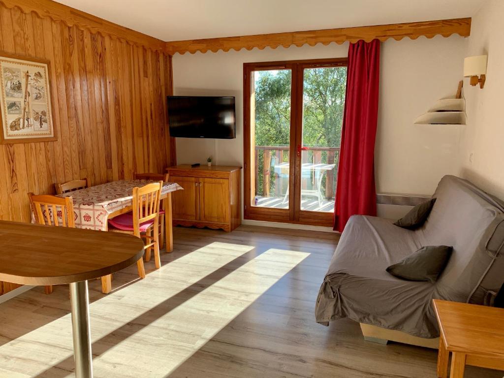 a living room with a couch and a table and a dining room at La Source Blanche Saint Jean Montclar in Saint-Jean Montclar