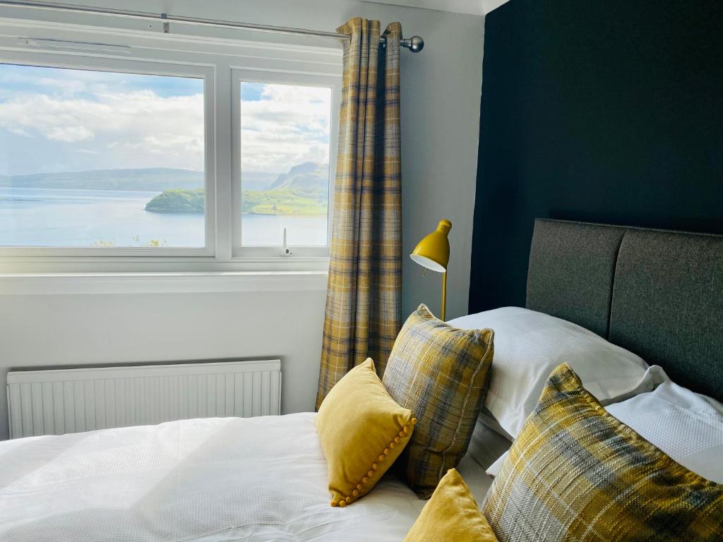 a bedroom with a bed with a large window at Hazelmount Self-Catering Cabin in Portree