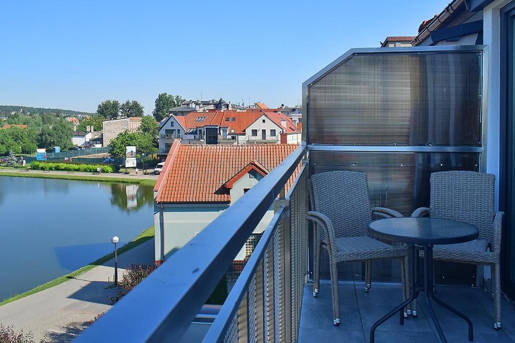 a balcony with a table and chairs and water at Apartamenty CityCenter in Mrągowo