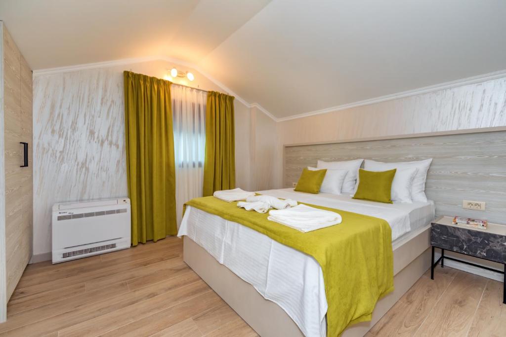 a bedroom with a large bed with yellow curtains at Luxury Apartments Queen in Petrovac na Moru