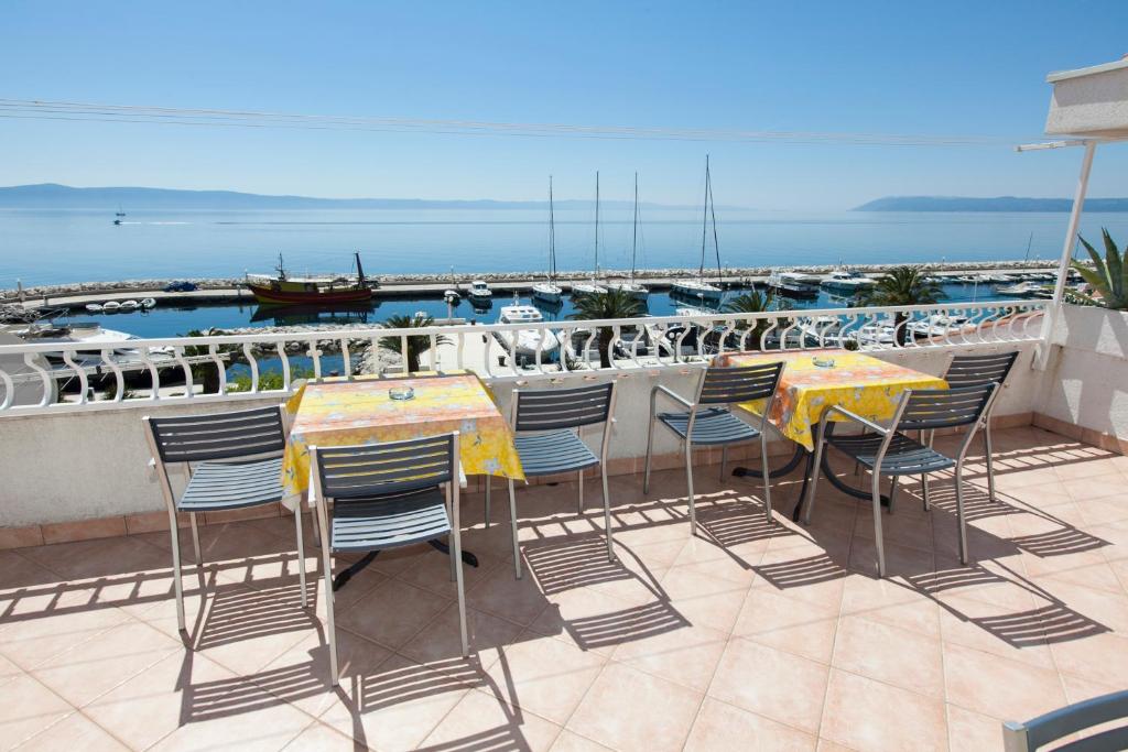 a patio with tables and chairs and a boat at Apartments Milana in Tučepi