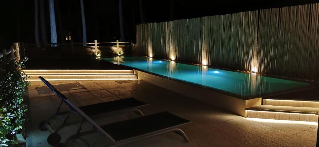 una piscina con luces encendidas por la noche en My Holiday Home - Aroeira Golf & Beach, en Charneca