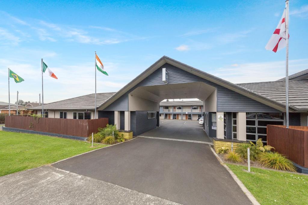 un bâtiment avec drapeaux devant lui dans l'établissement Aveda Motor Lodge, à Pukekohe East