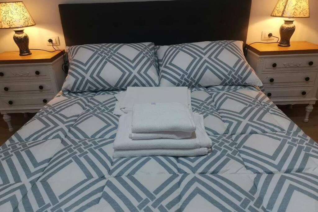 Una cama con un montón de toallas encima en Apartamento Lalín Centro ll, en Lalín