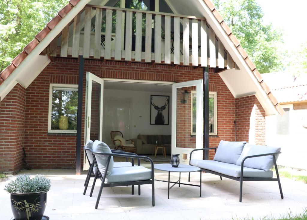 Olst的住宿－Guesthouse "Cosmea"，庭院配有两把椅子和一张桌子