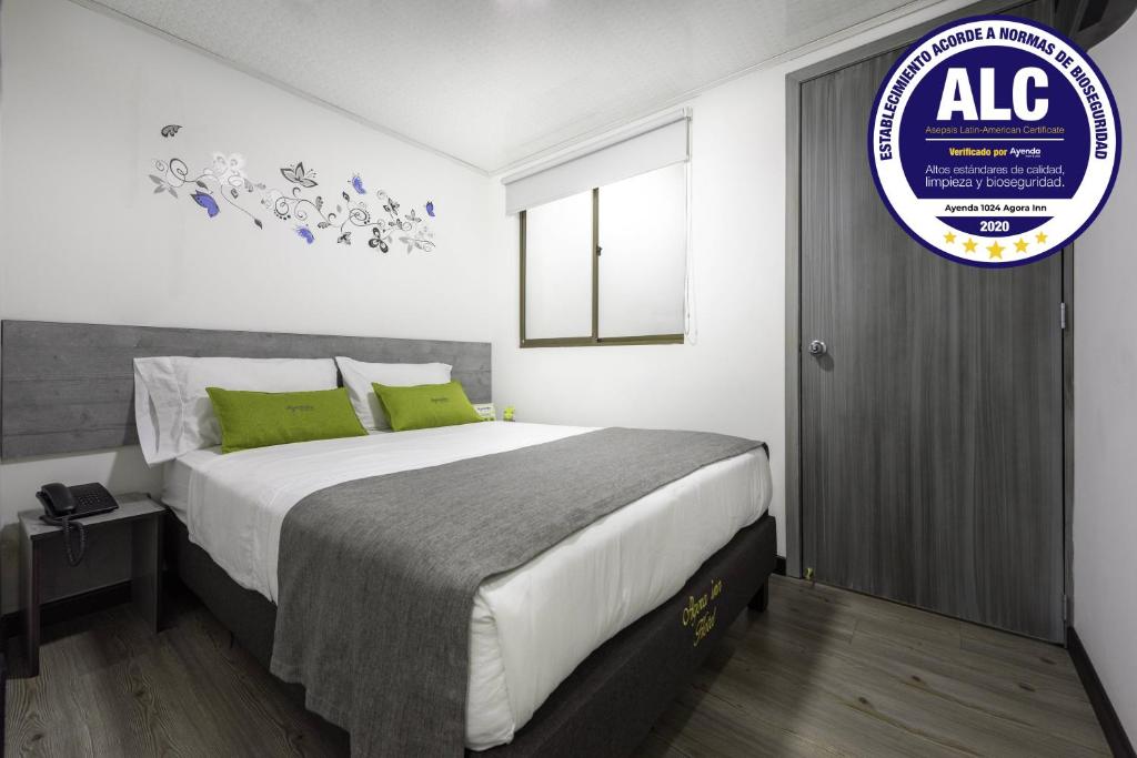 1 dormitorio con 1 cama grande con almohadas verdes en Ayenda 1024 Agora Inn Hotel, en Bogotá