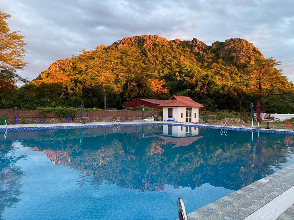 ein großer Pool mit einem Haus im Hintergrund in der Unterkunft Vạn Xuân Royal Hotel in Ninh Bình