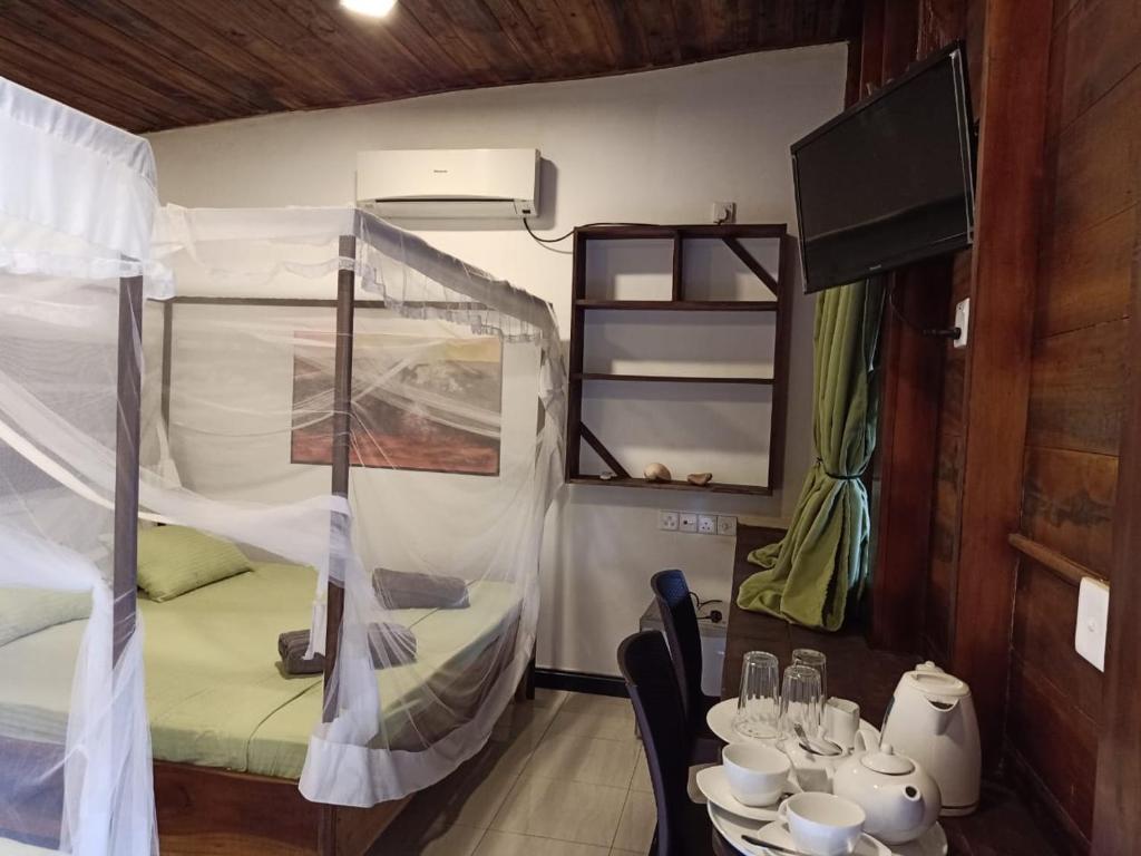 a small room with a table and a bunk bed at Garden Cottage Arugambay in Arugam Bay