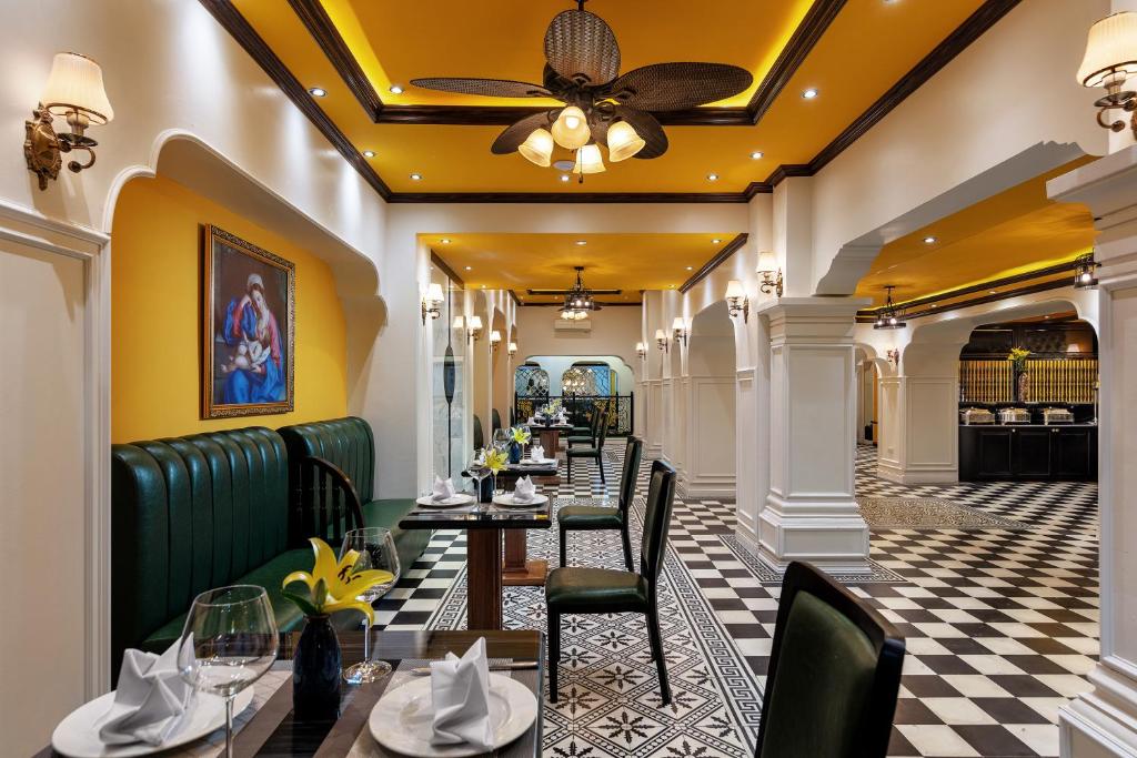 a restaurant with tables and chairs and a ceiling at Minerva Church Hotel in Hanoi