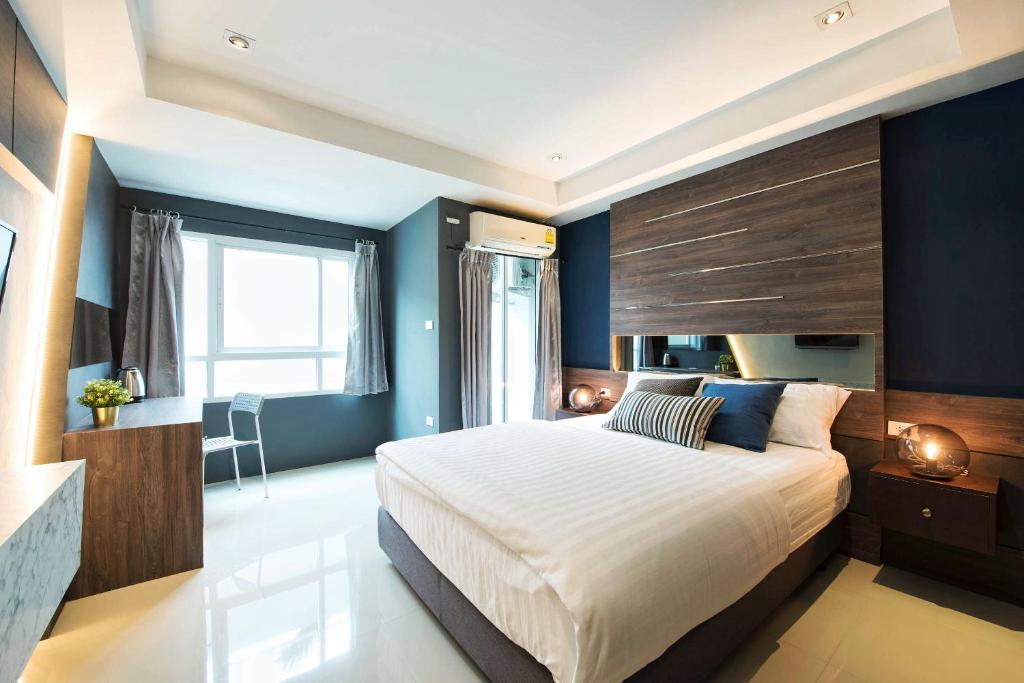 een slaapkamer met een groot bed en blauwe muren bij NW Apartment Lasalle 59 in Bangna