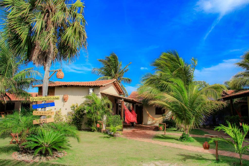 a house with palm trees in front of it at Pousada Vila Bella in Ponta do Anel